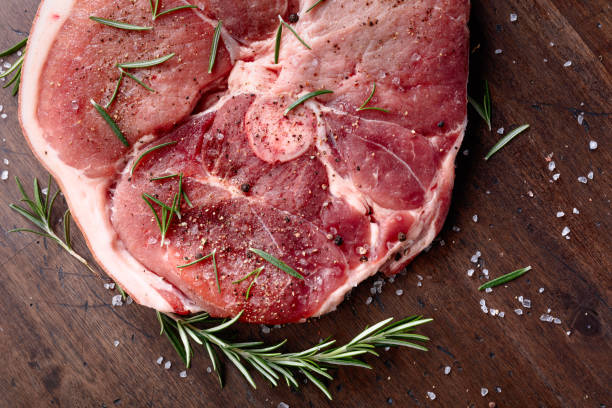 istock Raw pork with rosemary , salt and pepper. 870413084