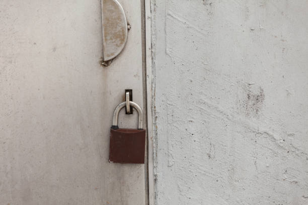 istock Old fashioned padlock on light grey steel door 870413924