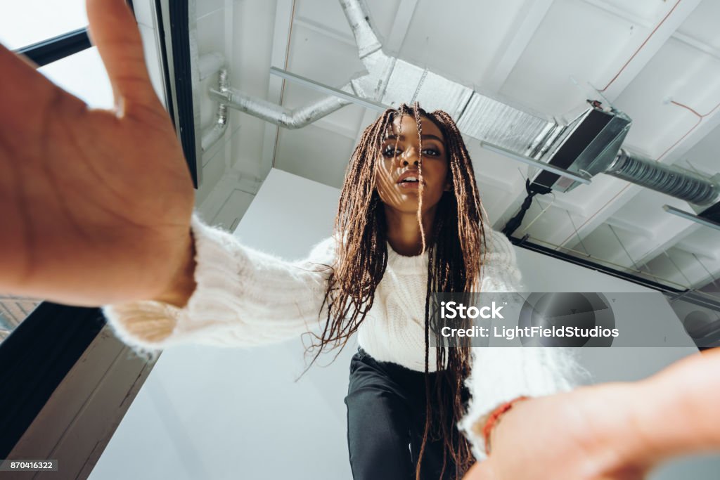 african american girl taking selfie low angle view of beautiful african american girl taking selfie Low Angle View Stock Photo