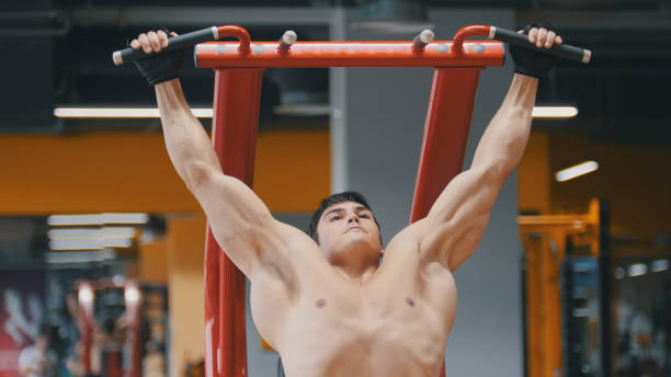 istock Muscular young man pulling up in a gym, close up 870416588