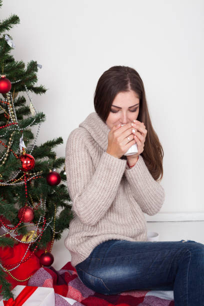 istock girl drinking coffee under the Christmas tree new year tea 870419976