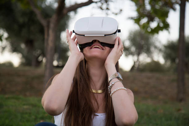 istock Young woman enjoying experience in VR glasses 870430766