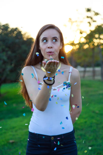 istock Young woman blowing confetti 870430872