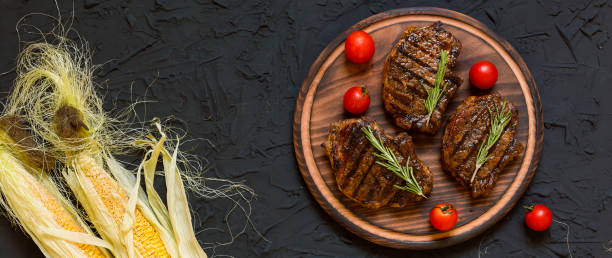 Steak grill, barbecue corn on the black background. closeup