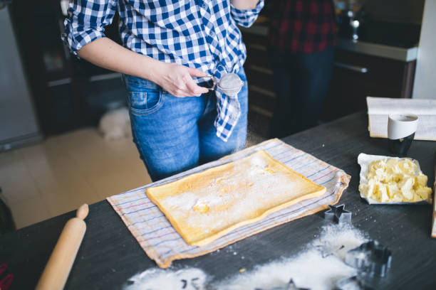istock Female baker or pastry chef sprinkles powdered sugar. motion blur, selective focus. Closeup. 870434576
