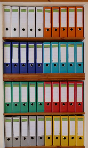 istock Colorful ring binders in a wooden shelf 870438416
