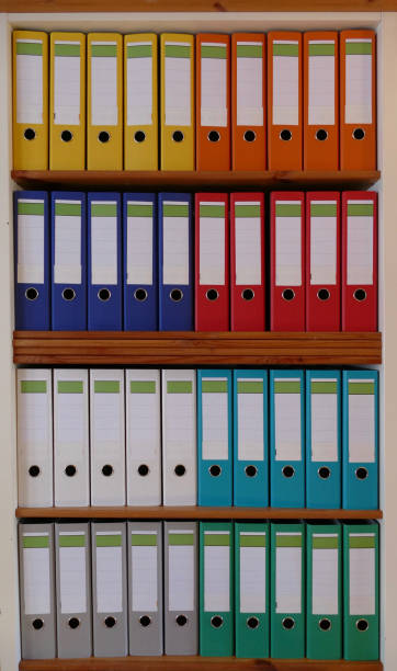 istock Colorful ring binders in a wooden shelf 870438510