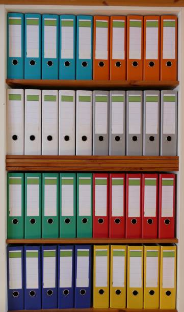 istock Colorful ring binders in a wooden shelf 870438532