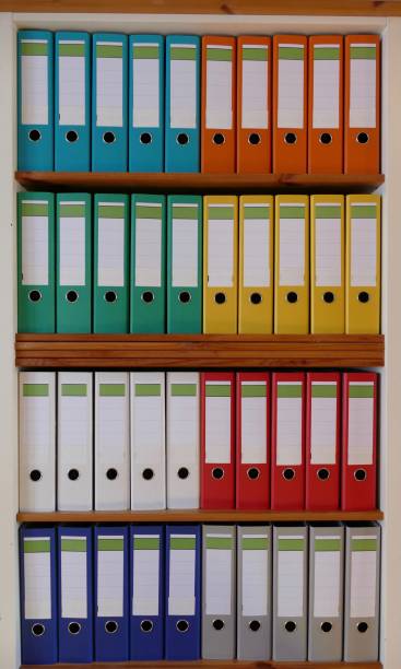 istock Colorful ring binders in a wooden shelf 870438556