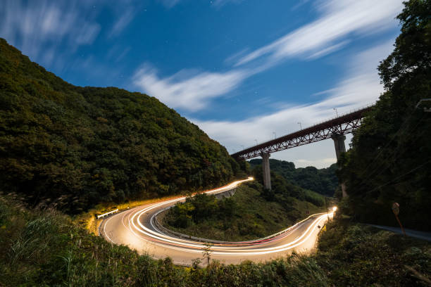 istock Light trails from a car passing through a hairpin turn on a ountain road 870441988
