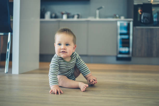 istock Little baby on kitchen floor 870442300