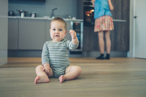 istock Little baby on kitchen floor 870442354