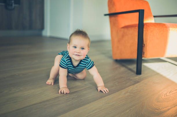 A cute little baby is crawling around a modern apartment in the sunslight