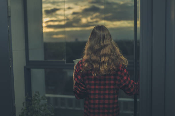 istock Woman on balcony admiring sunrise 870445456