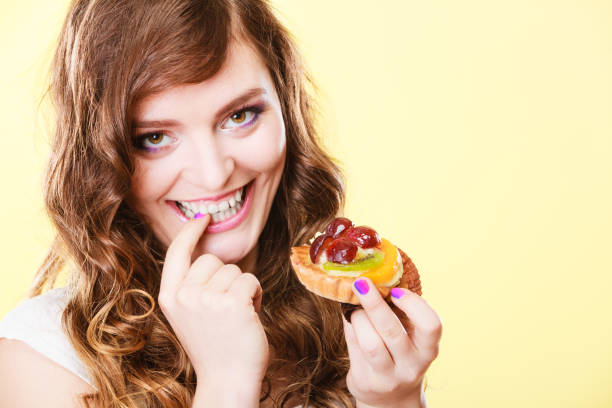 istock Closeup flirty woman eating fruit cake 870448694