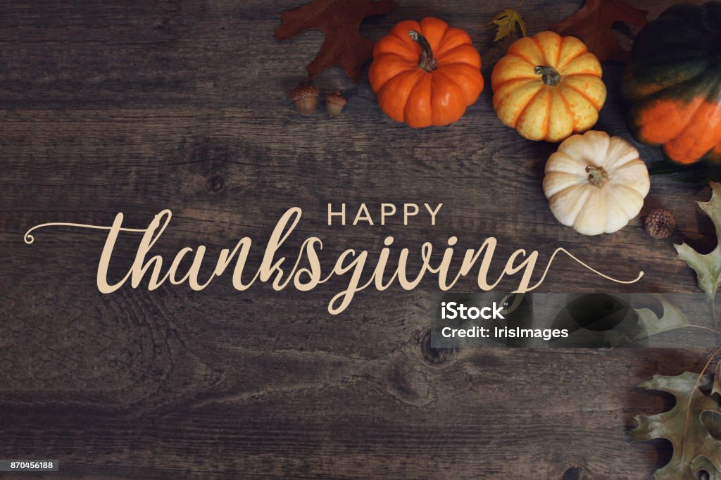 Happy Thanksgiving text with pumpkins and leaves over dark wood background Happy Thanksgiving words with pumpkins and leaves over dark wooden background Thanksgiving - Holiday Stock Photo