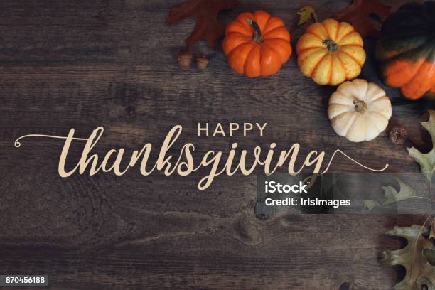 Happy Thanksgiving Text With Pumpkins And Leaves Over Dark Wood Background Stock Photo - Download Image Now