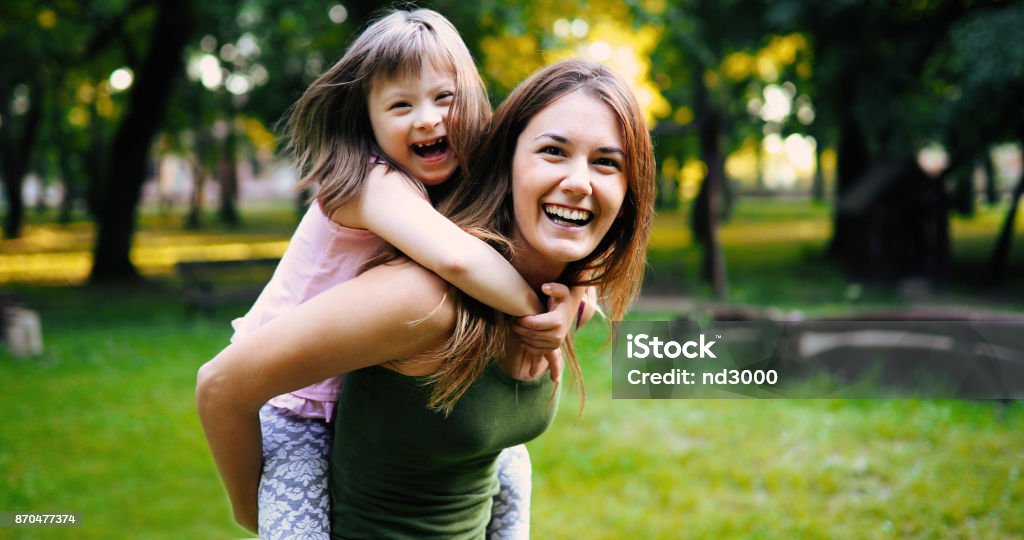 Niña con especial necesita disfrutar de pasar tiempo con la madre - Foto de stock de Diversidad funcional libre de derechos