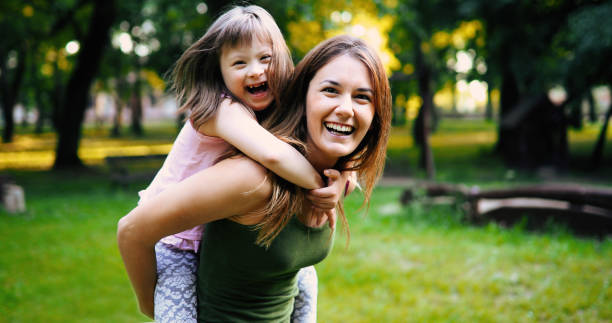 Little girl with special needs enjoy spending time with mother Little girl with special needs enjoy spending time with mother in nature down syndrome photos stock pictures, royalty-free photos & images