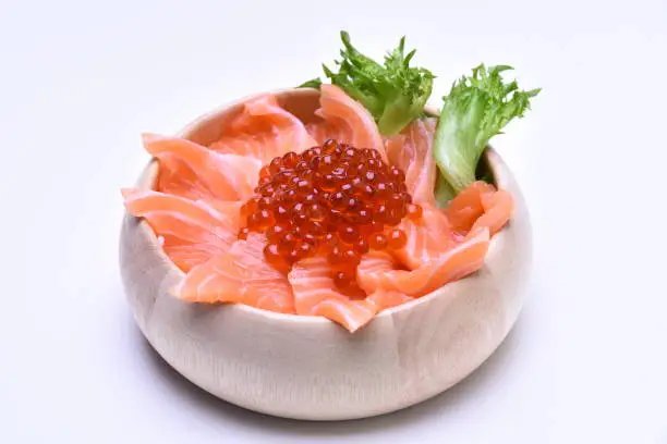 Salmon slide and salmon roes on wooden bowl (white background)