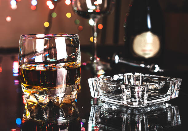 glass with whiskey and crystal ashtray on the table in the bar