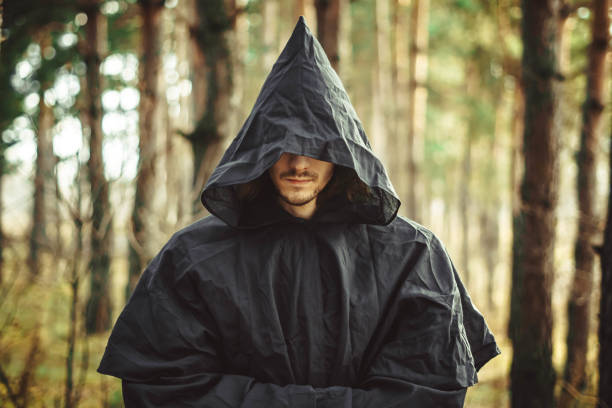 a monk in the hood A creepy man in a black hood in the forest ceremonial robe stock pictures, royalty-free photos & images