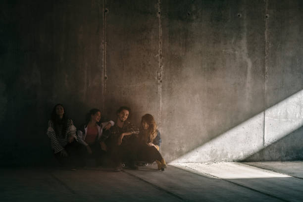 istock Young adults sitting in dark concrete garage 870486052
