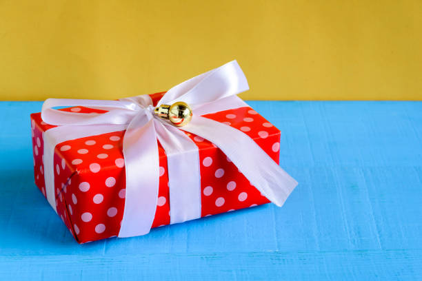istock gift boxes on wood desk yellow wall background 870486176