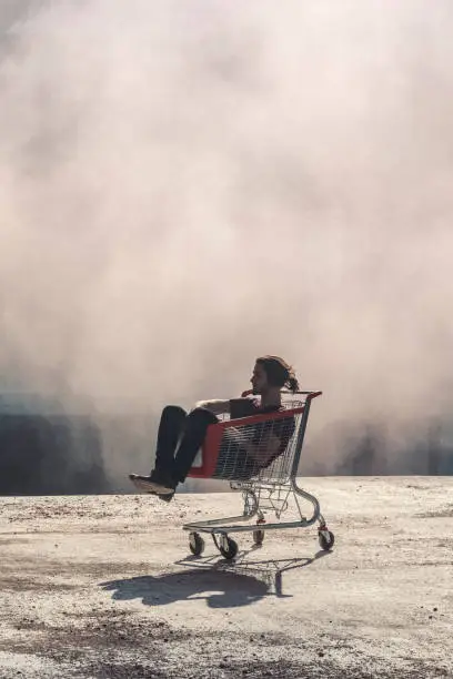 Photo of Young adult resting in shopping trolley