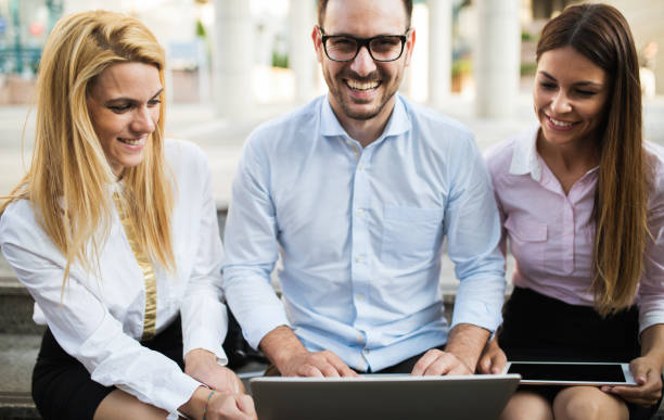 istock Three young smiling colleagues working together on laptop 870489368
