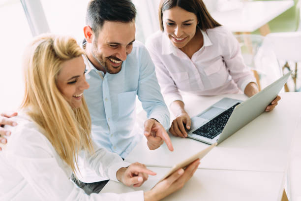 istock Three young smiling colleagues working together on laptop 870492500