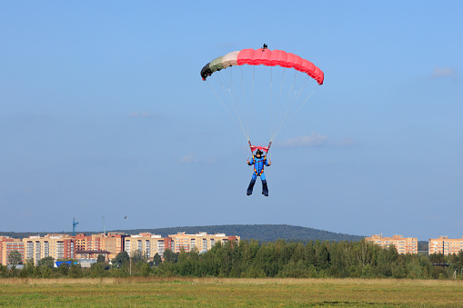 parachutist landed on  green field on  summer day