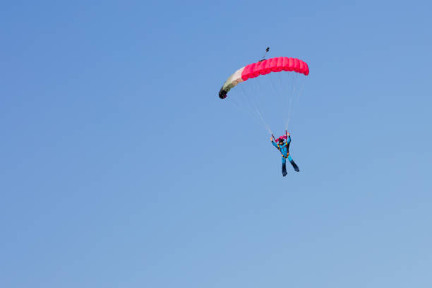 istock skydiver on pink parachute on background blue sky 870493028