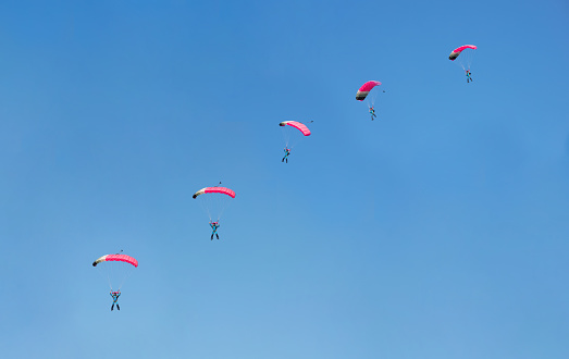burst photo effect of parachutist on background blue sky