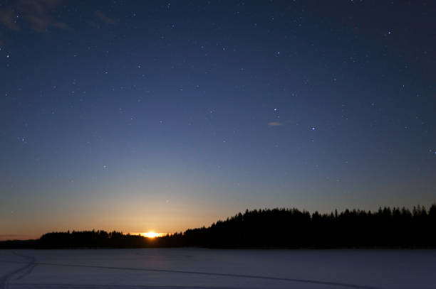 луна, поднимающаяся над зимним пейзажем ночью - lake night winter sky стоковые фото и изображения