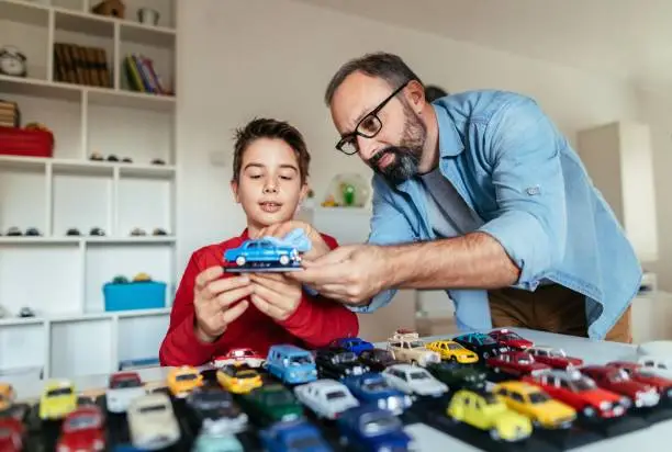 Photo of father and son with his car collection