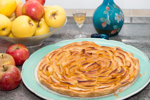 beautiful apple pie with apples and small glass of Calvados