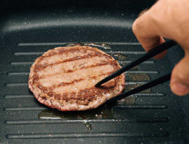istock Turning delicious burger preparation in grill pan at home 870510974