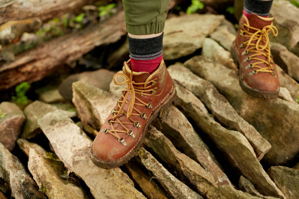 istock Person in hiking boots walking over stones 870514462