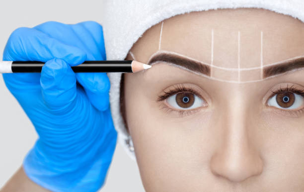 istock Permanent make-up for eyebrows of beautiful woman with thick brows in beauty salon 870517528