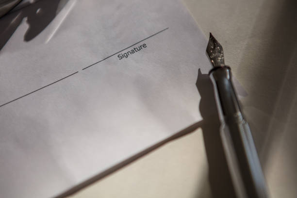 Close-up of Male hand signing a Quebec tax declaration document with a shallow depth of field.