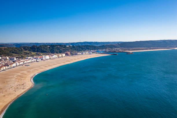 istock nazare beach under blue sky, portugal 870524614