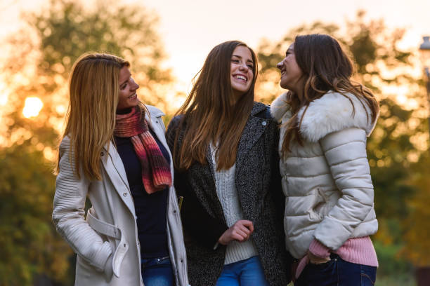 istock Three female friends walking in spring park 870527586