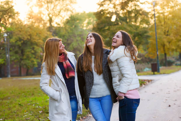 istock Three female friends walking in spring park 870527722