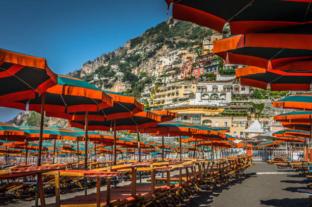 Umbrellas line the beach of Positano, Amalfi Coast, as the town prepares for another hot summer day of tourists and local beachgoers.