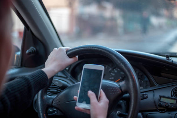 istock Frontal view of modern smart phone with blank white screen with copy space for your text or design, close up of driver hands using mobile phone in car 870538722