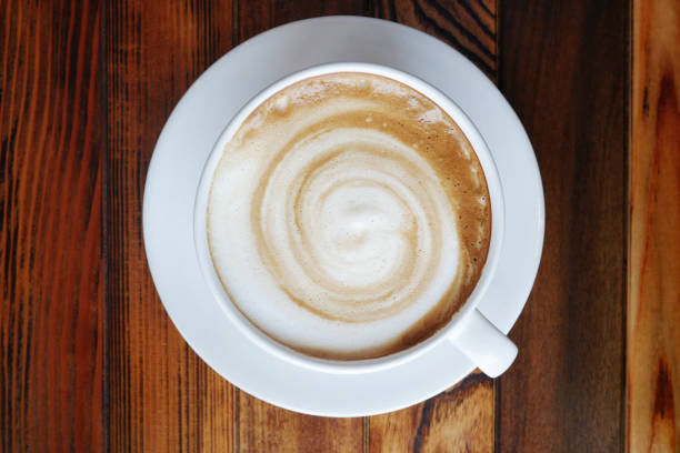 istock Top view of hot coffee latte cappuccino cup on plank wood table texture background. 870538904