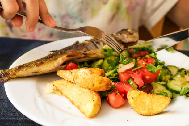 istock Fish, fried potatoes and salad from fresh vegetables 870539314