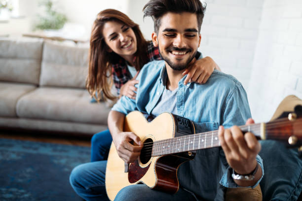 istock Young handsome man playing guitar for his girlfriend 870542630