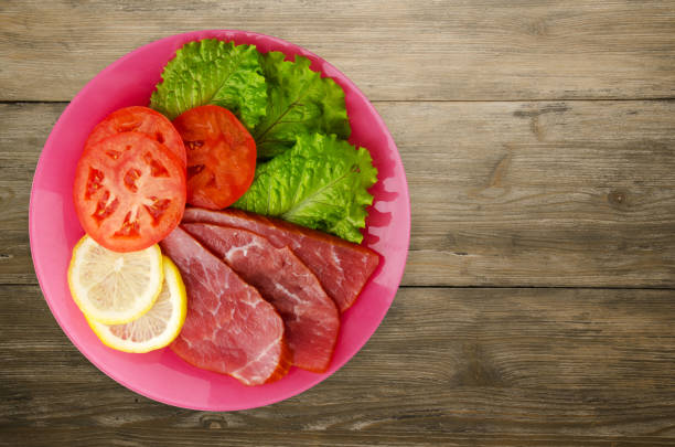 istock ham with salad, tomato and lemon on a plate. 870547802